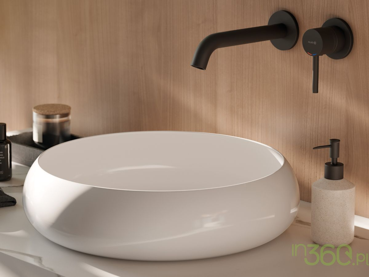 Czarna bateria umywalkowa podtynkowa Kludi Bozz w minimalistycznym stylu. Elegancka, matowa powierzchnia harmonijnie komponuje się z drewnianą ścianą i białą umywalką nablatową o zaokrąglonym kształcie.