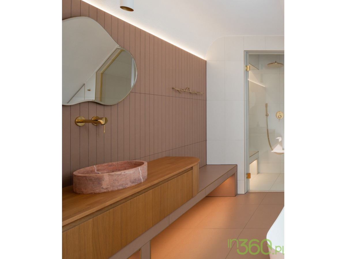 : Jasna łazienka z białą wanną, złotą armaturą Grohe i prysznicem z deszczownicą Rainshower Cosmopolitan