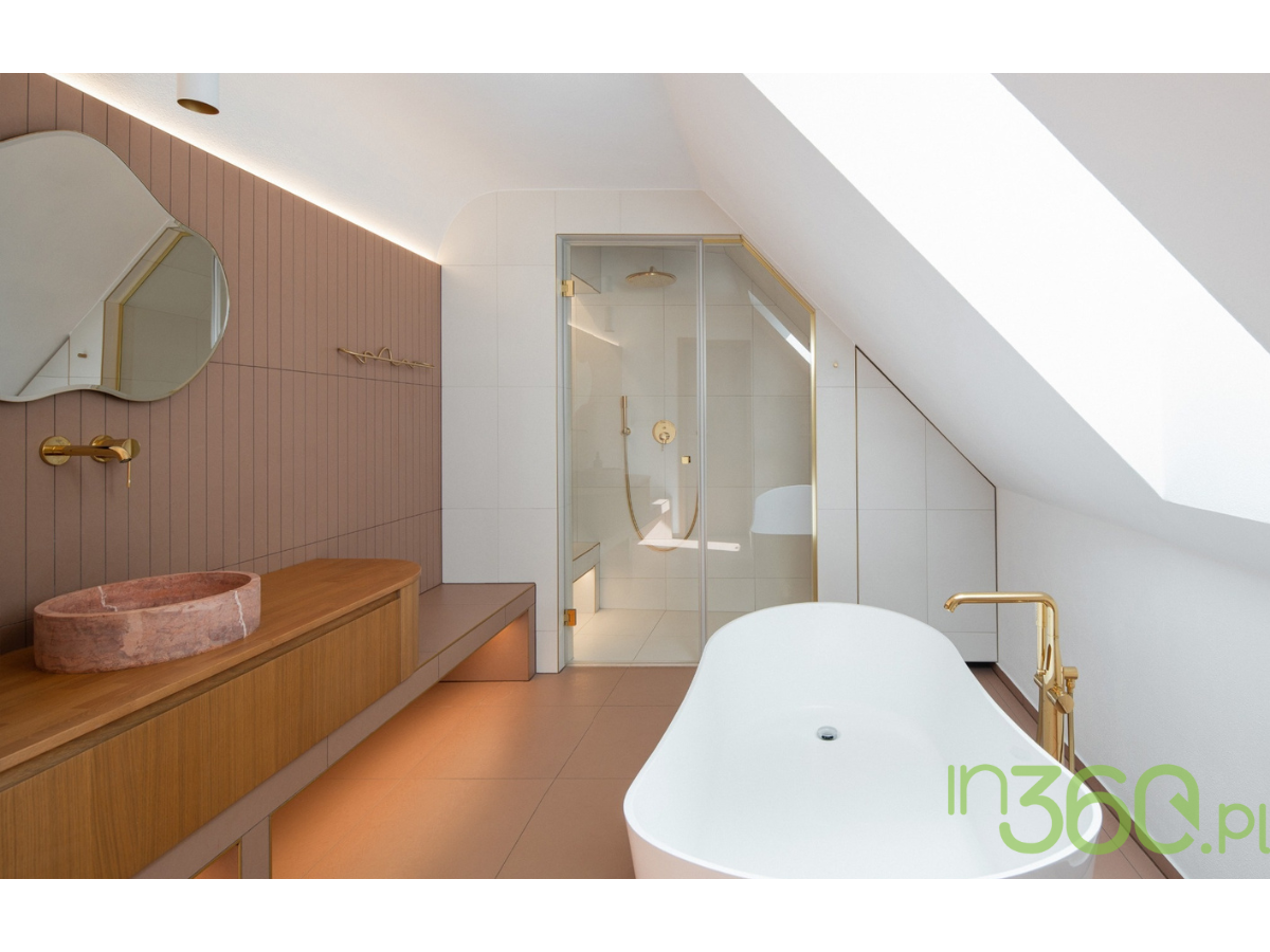 Wolnostojąca wanna z baterią Grohe Essence Brushed Cool Sunrise w minimalistycznej łazience