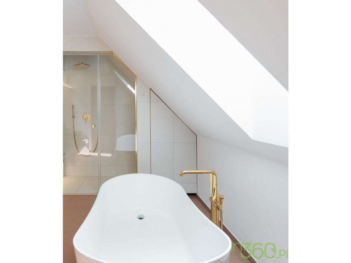 Jasna łazienka z białą wanną, złotą armaturą Grohe i prysznicem z deszczownicą Rainshower Cosmopolitan