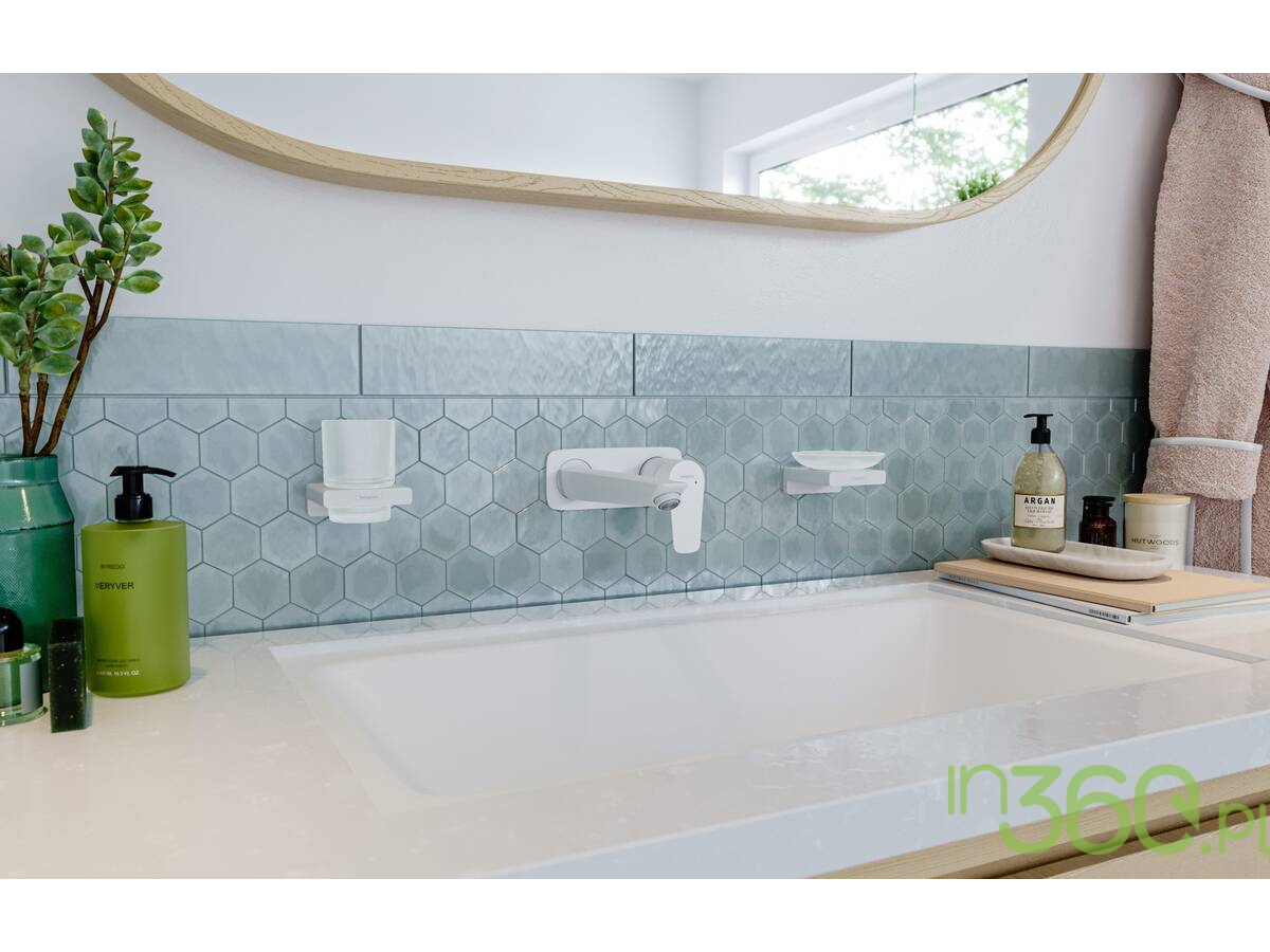 Bateria umywalkowa Hansgrohe Metropol w białym macie zamontowana na tle błękitnych płytek Marazzi Mystone Berici
