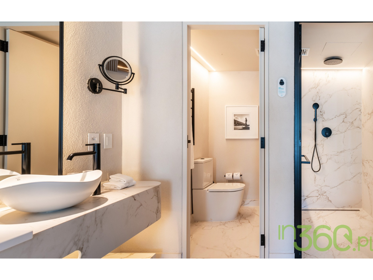 Elegancka łazienka z czarną armaturą i marmurowymi płytkami — aranżacja Roca