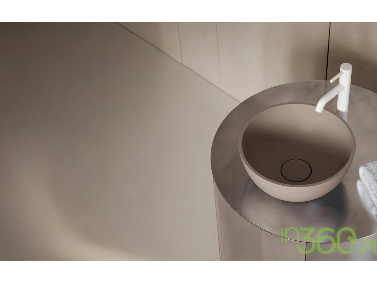 Zbliżenie na umywalkę nablatową w kolorze beżowym z białą baterią umywalkową Omnires Y na lustrzanym, stalowym blacie