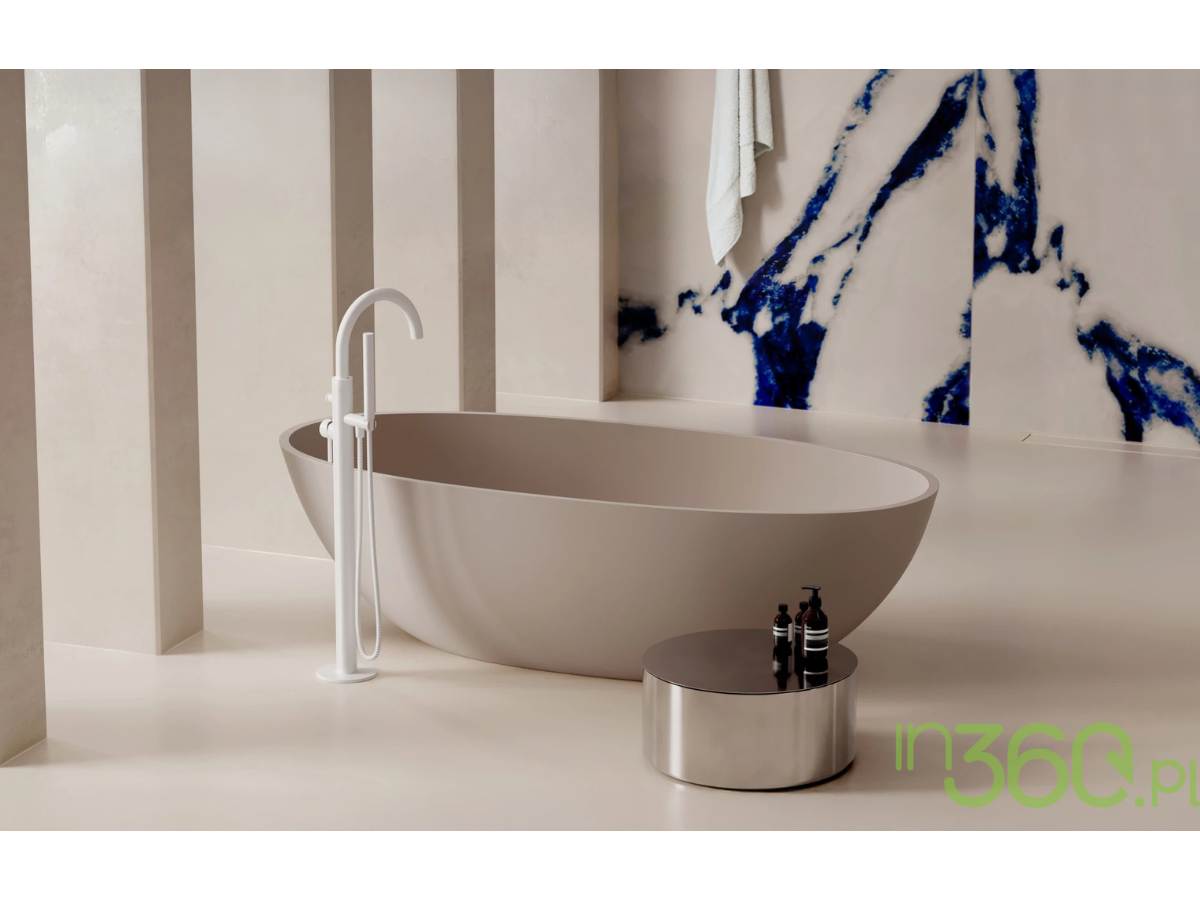 Elegancka beżowa wanna wolnostojąca Omnires z białą baterią wannową i minimalistycznym stolikiem z akcesoriami kąpielowymi