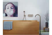 Przestronna łazienka marki Axor, wyposażona w wolnostojącą wannę i elegancką baterię, jasne wykończenia oraz minimalistyczny design, idealna do luksusowych wnętrz.