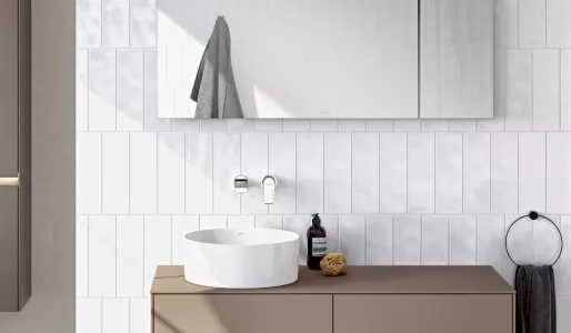 biała umywalka nablatowa w nowoczesnej łazience z białymi płytkami i minimalistyczną szafką