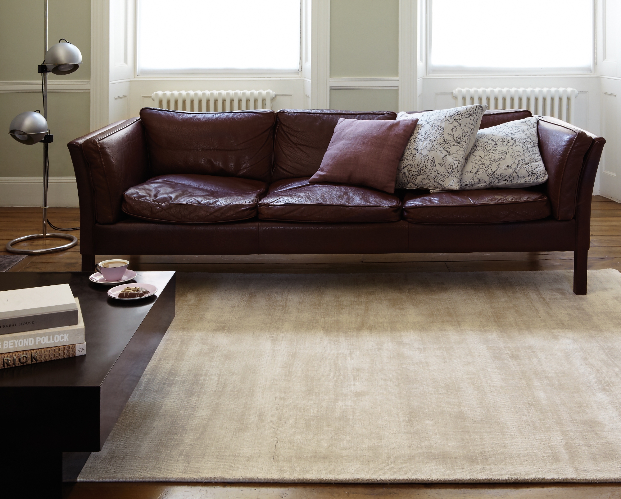 beżowy dywan ze skórzaną kanapą