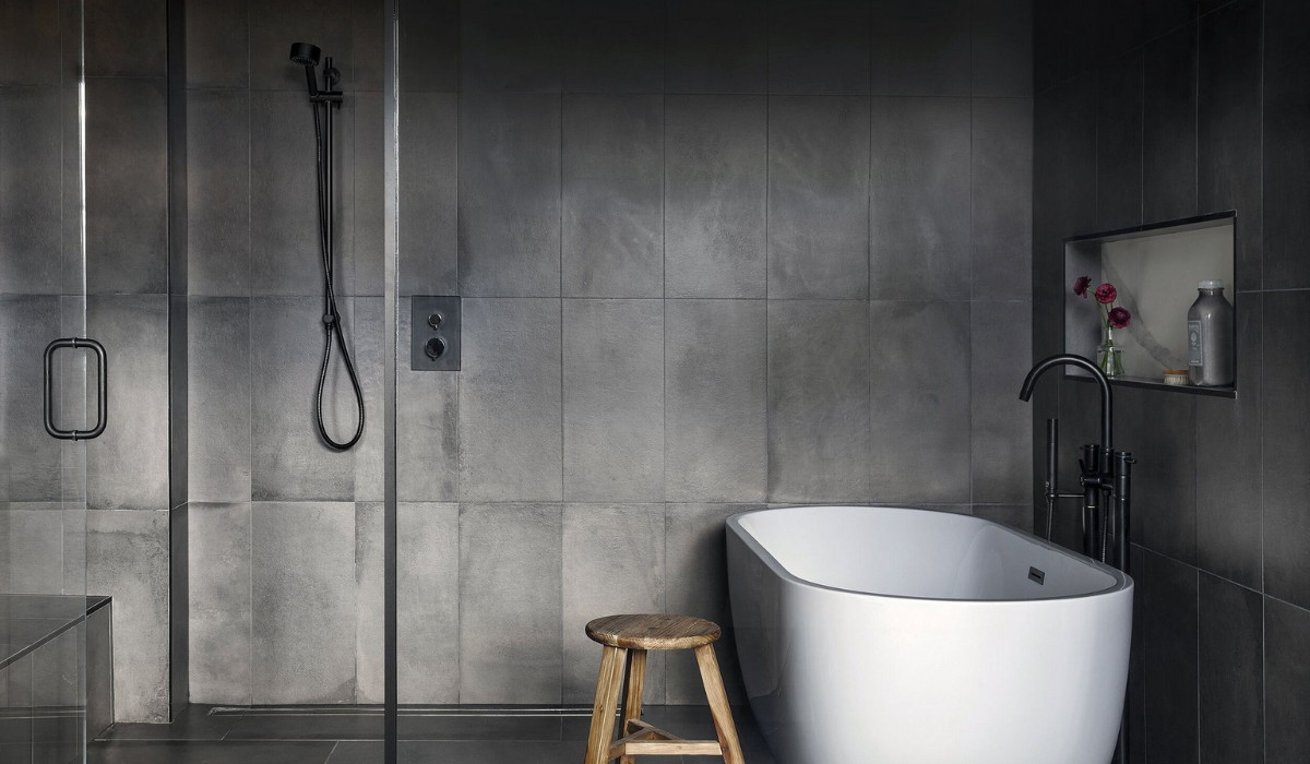Minimalistyczna łazienka z betonem i czarną armaturą Ciemna łazienka soft brutalism z wanną wolnostojącą i prysznicem