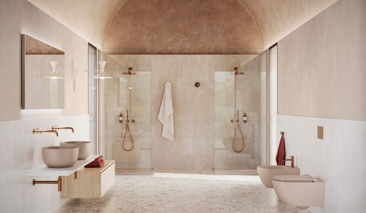 Nowoczesna beżowa łazienka z podwójnym prysznicem i eleganckimi bateriami w odcieniu złota. Minimalistyczna jasna łazienka z dwiema umywalkami, podwójnym prysznicem i delikatną złotą armaturą.