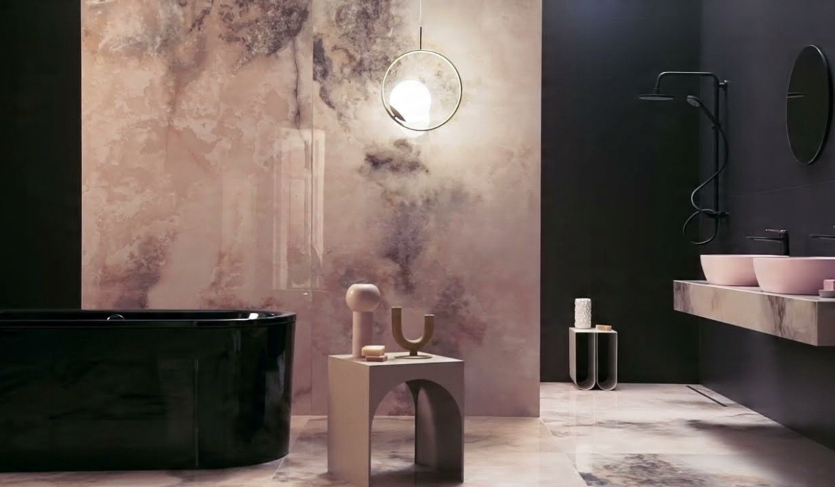 Elegancka łazienka z płytkami Onice Rosa i czarną wanną wolnostojącą