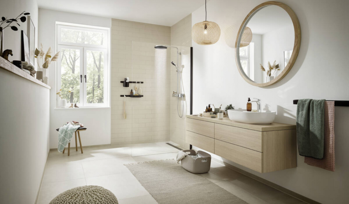 eria Raindrain Hansgrohe – nowoczesna łazienka z prysznicem walk-in Nowoczesna jasna łazienka z prysznicem walk-in i odpływem liniowym Hansgrohe Raindrain, drewniana szafka pod umywalkę, okrągłe lustro – seria-raindrain-hansgrohe