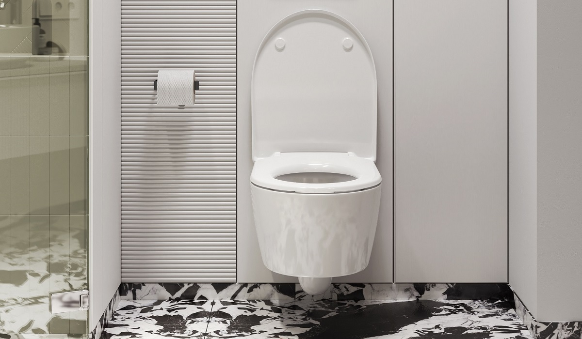 Nowoczesna podwieszana miska WC bezrantowa w minimalistycznej łazience z zieloną ścianą i drewnianą podłogą.